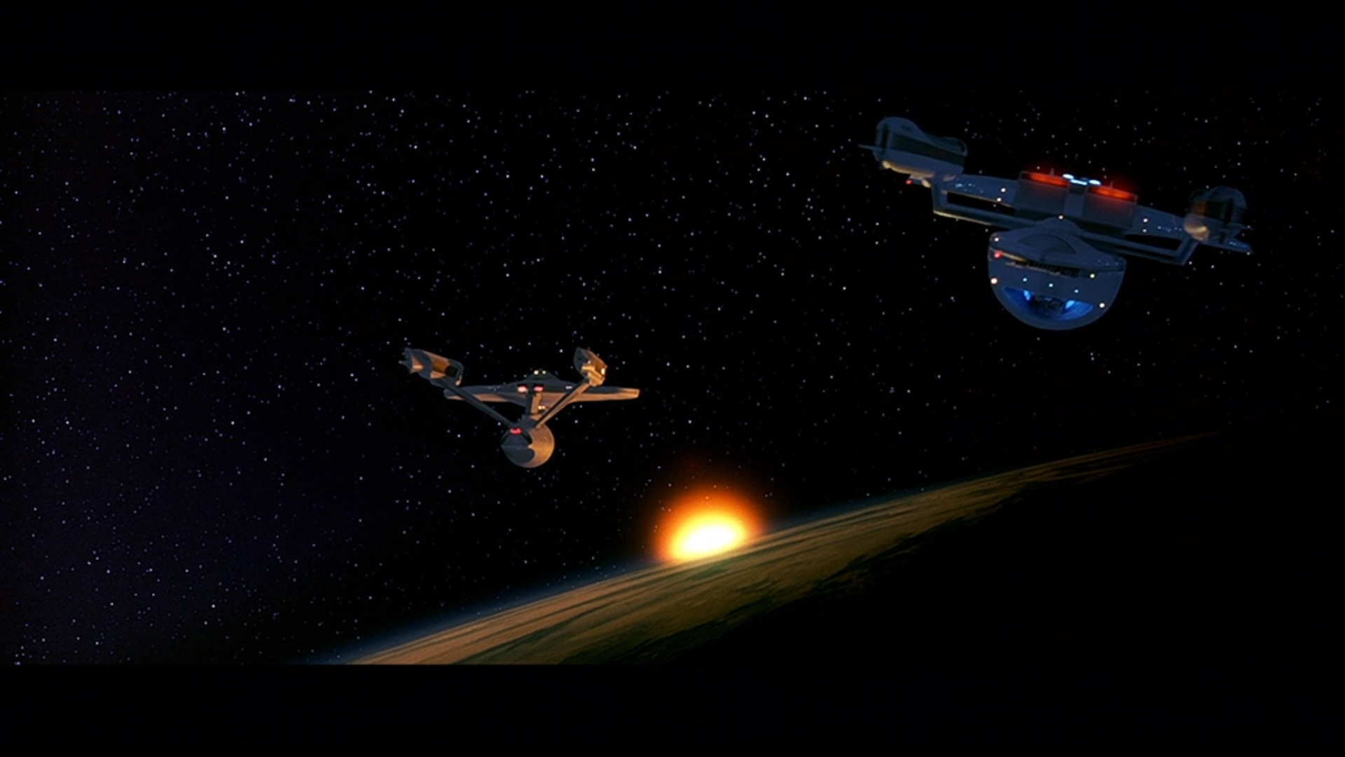 A shot of the Enterprise (on the left) and the Excelsior (on the right) side by side orbiting the planet Khitomer with it's sun partially seen behind the planet's curvature.  The Excelsior is starting to pull away to the right.