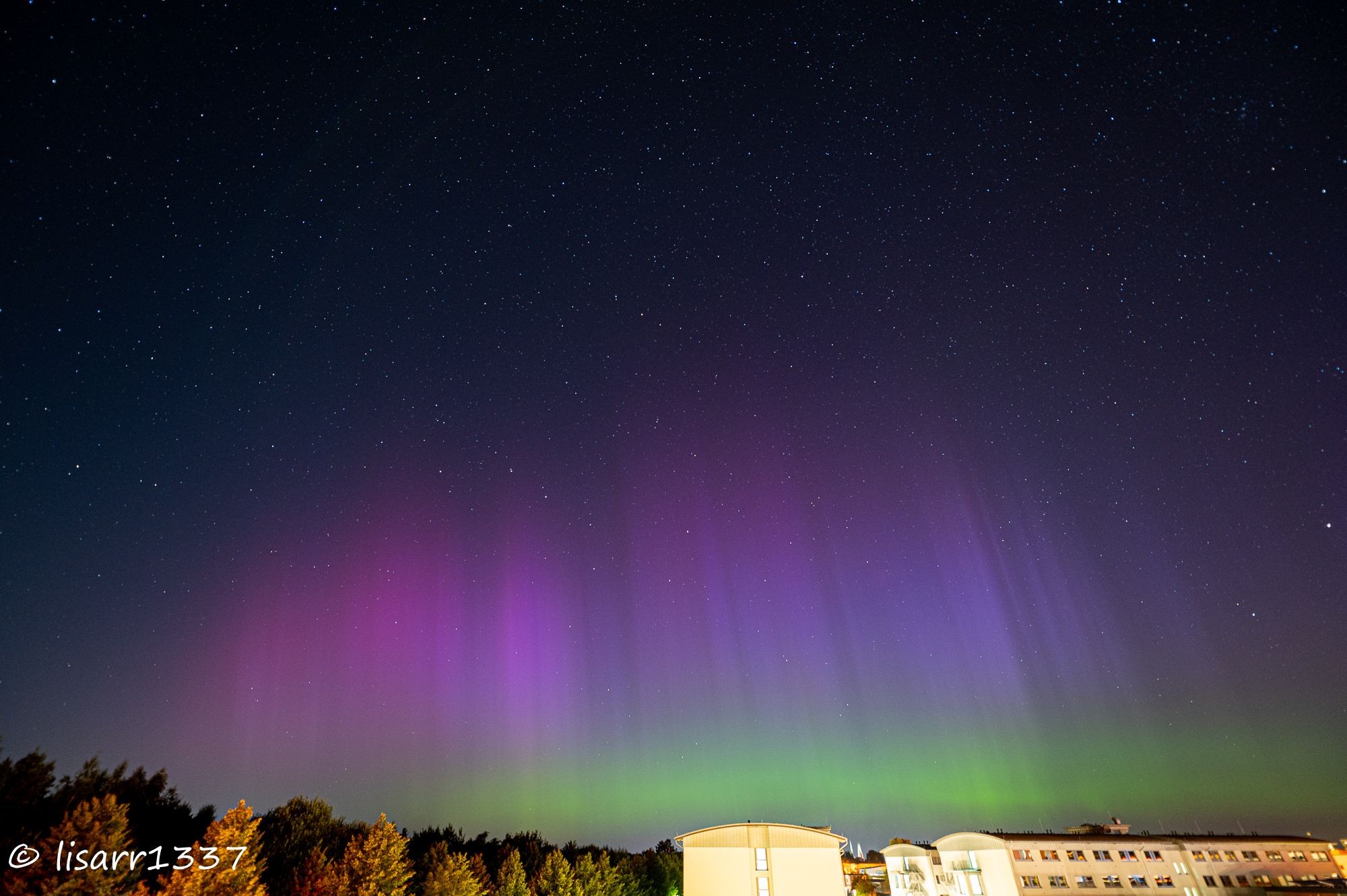 Polarlicht in pink und grün über den Dächern Lübecks