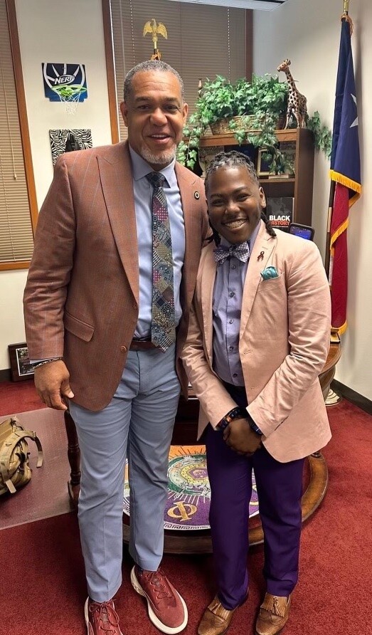 Two Black men pose in suit jackets in a legislator's office: Representative Jarvis Johnson, author of the sickle cell bill, with André Harris Marcel, an advocate for sickle cell disease patients.