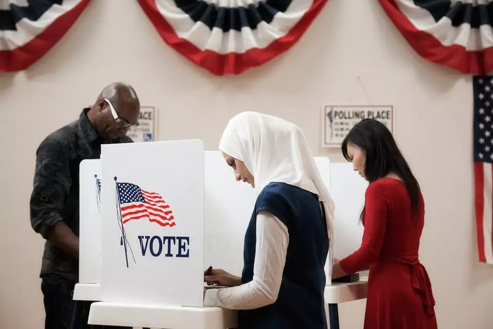 Voters fill out ballots at a polling place.