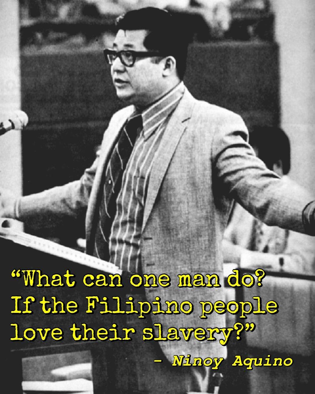 Black and white photo of former Filipino senator Ninoy Aquino on a podium appearing to make a speech. Text written below reads, "What can one man do? If the Filipino love their slavery?"