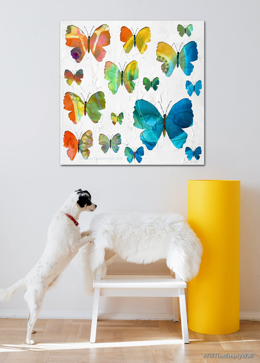 Colorful butterflies in the rainbow of colors on a textured white background by artist and poet Sharon Cummings.  Set in a furniture setting with a little dog, white chair and yellow cylinder.  Haiku in post.