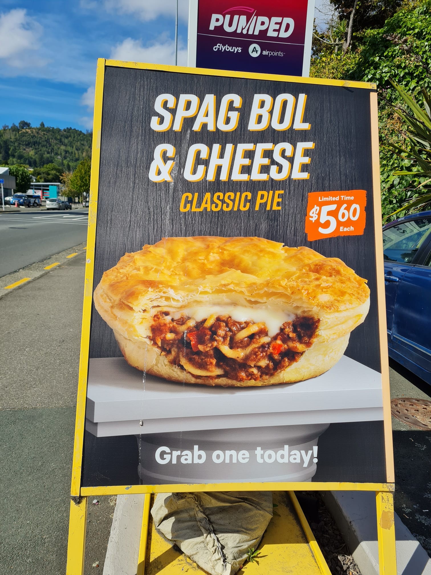 You're looking at a service station advertisement for a Spag Bol & Cheese Classic Pie with a picture of yes, a spag bol & cheese pie with a bite taken out of it. They're 5.60 in case you're wondering how much. And it's sitting on a really weird stand. Like a white board on top of a white oil drum that makes it look like the pie is actually the size of a continent maybe. Or at least a small hatchback. This is a pie that wants you to know it's here and that it brought its friends. This pie was spotted on my walk to my favourite cafe where I had a scone. Not this pie. But I want to know if this pie is a thing in New Zealand. Because it is, after all a pie. And pies, while sometimes an abomination, are generally awesome.