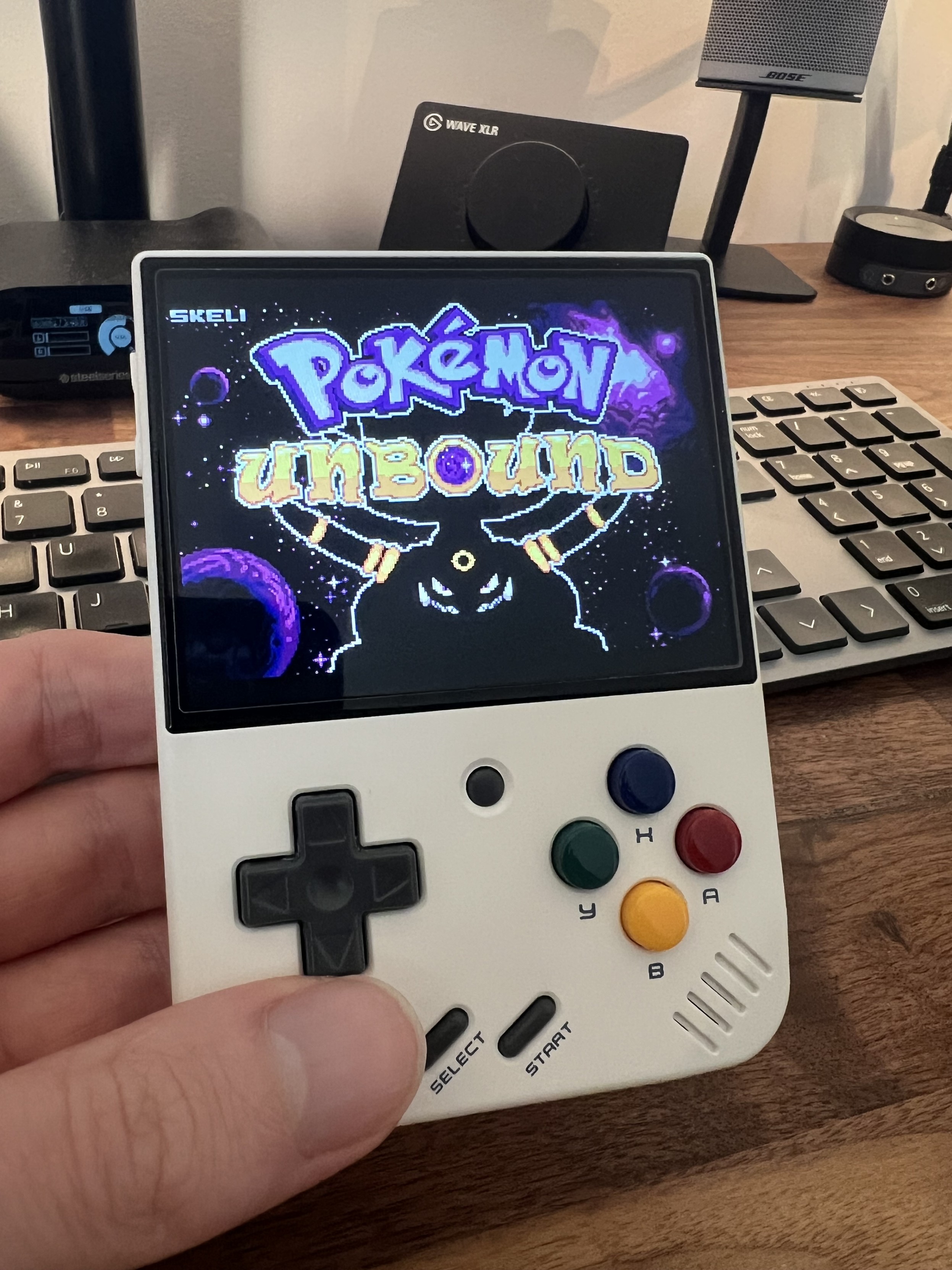 Photo of the white Miyoo Mini Plus with the Pokémon Unbound start screen on display.