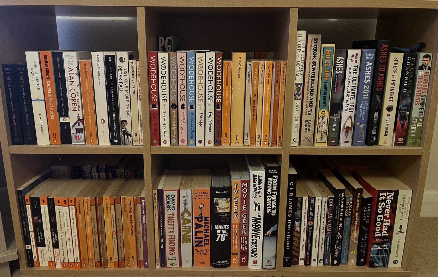 Book shelf quite neat full of books including a number of PG Wodehouse novels